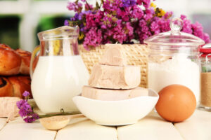 Dry yeast with pastry and baking ingredients on wooden table on natural background